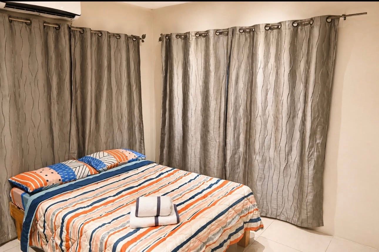 Family Apartment bedroom with queen bed and curtains
